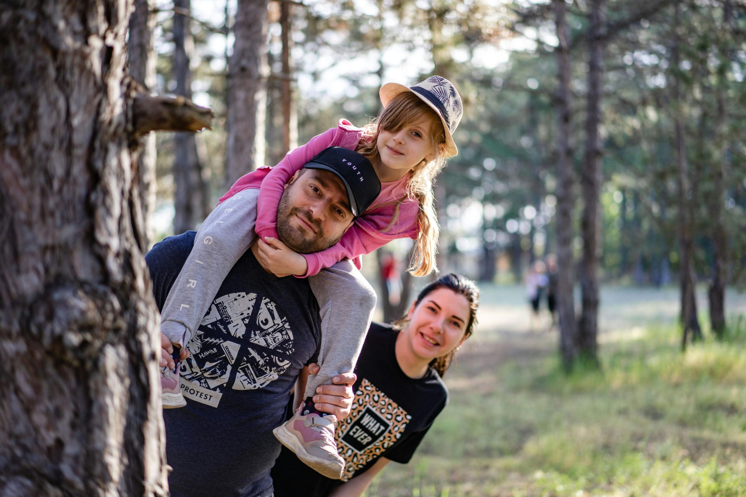 A joyful family enjoying a playful day in a sunlit forest park, capturing the essence of togetherness.